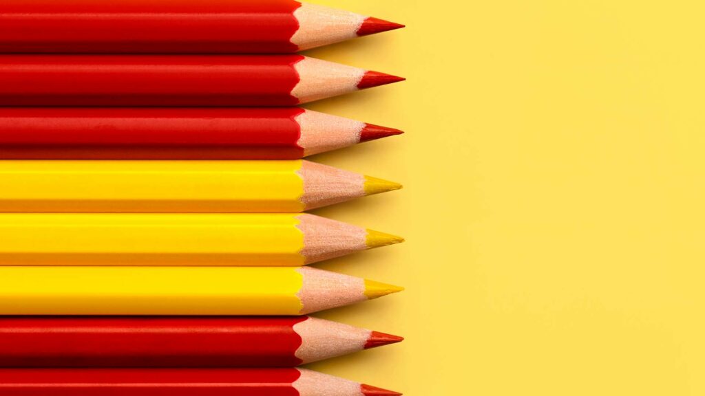Rote und gelbe Bleistifte auf gelbem Hintergrund