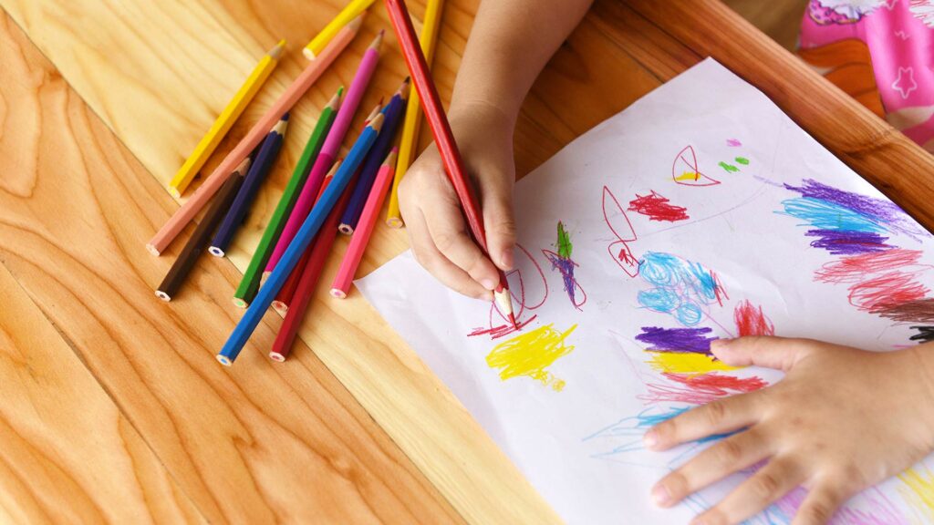 Toddler coloring and drawing with colored pencils