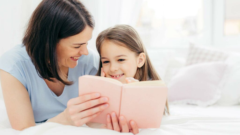 Mother and girl reading a book together